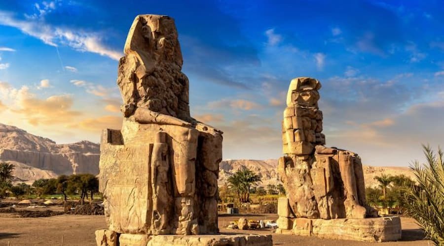 Two massive stone statues of Pharaoh Amenhotep III known as the Colossi of Memnon in Luxor